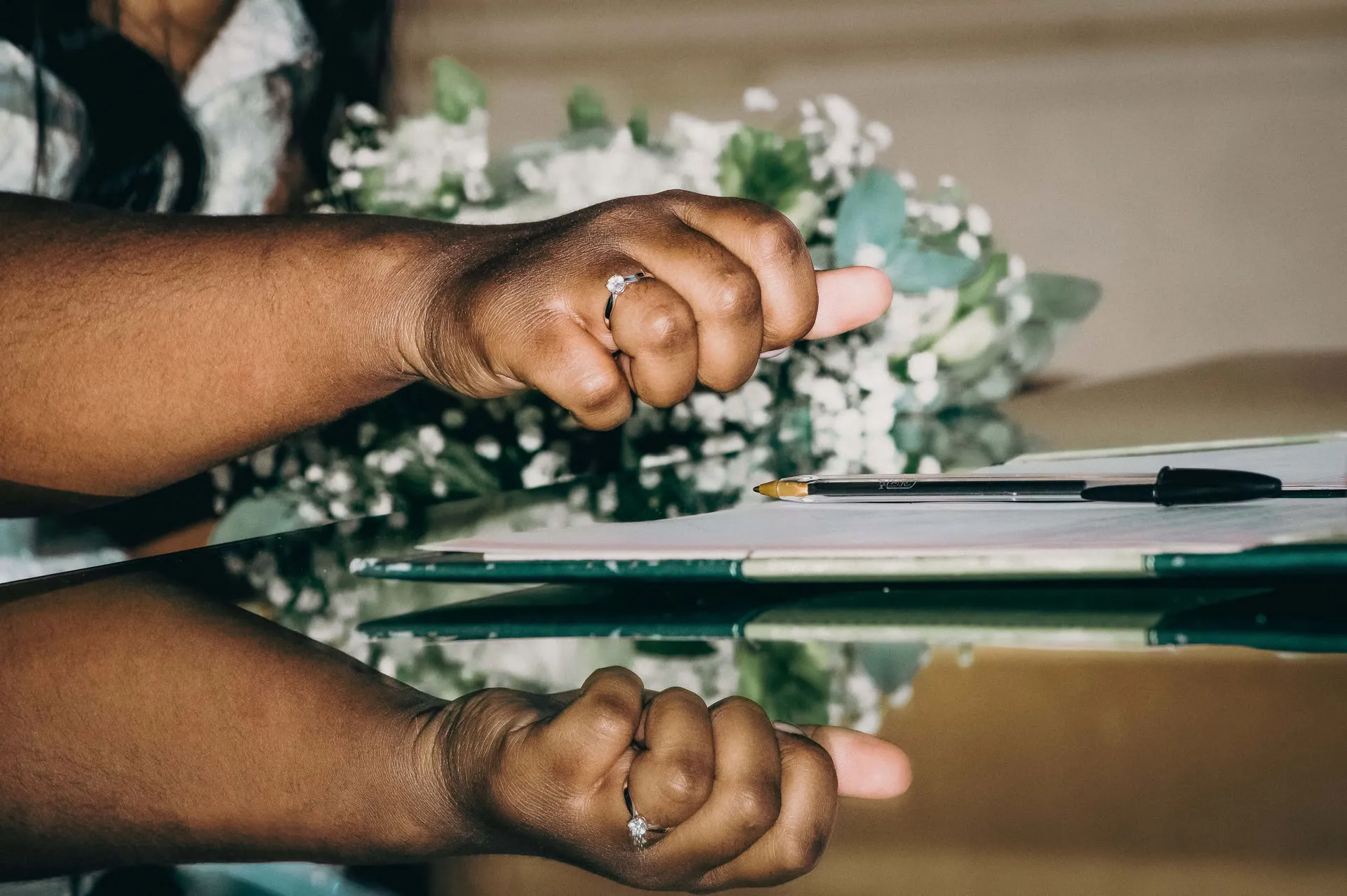 Mariage, gros plan sur le bras de la mariée entrain de signer à la mairie